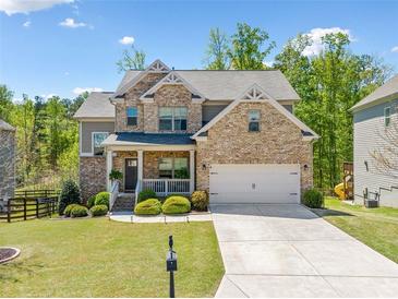 Charming two-story brick home with a well-manicured lawn and a two-car garage at 5780 Winding Lakes Dr, Cumming, GA 30028