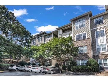 Attractive multi-level condo building with beige siding and manicured landscaping at 2700 Pine Tree Ne Rd # 1015, Atlanta, GA 30324