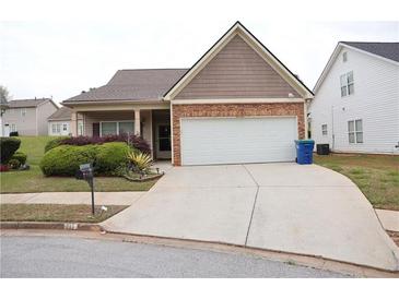 Charming home featuring a two-car garage, stone accents, and well-maintained landscaping at 115 Catlyn Ct, Riverdale, GA 30296