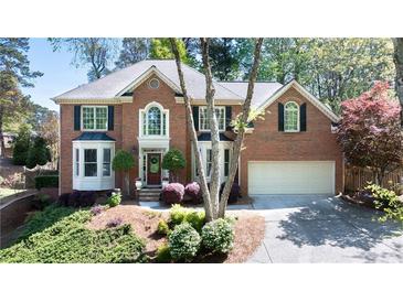 Charming two-story brick home featuring manicured landscaping and a well-maintained front yard and a two-car garage at 5405 Preserve Cir, Johns Creek, GA 30005