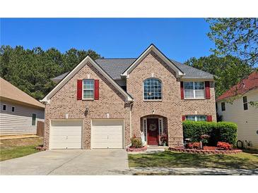 Charming brick two-story home with a well-manicured lawn and a two-car garage at 542 Simonton Ridge Trl, Lawrenceville, GA 30045