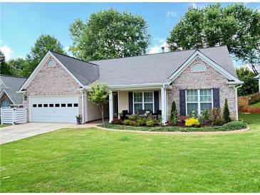 Charming single-story home features a brick facade, well-manicured lawn, and attached garage at 4025 Mcdowell Dr, Acworth, GA 30101