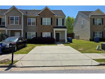Traditional two-story townhouse featuring brick accents, tidy landscaping, and a concrete driveway at 2225 Bigwood Trl, Atlanta, GA 30349