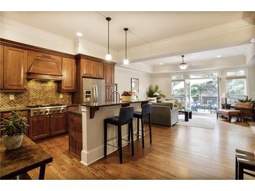 Modern kitchen open to living room with stainless steel appliances and breakfast bar at 225 Mystic Ridge Hl, Sandy Springs, GA 30342