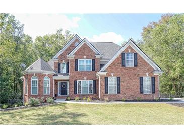 Beautiful two-story brick home with a manicured lawn and classic black shutters for a welcoming curb appeal at 1213 Blue Springs Dr, Loganville, GA 30052