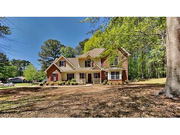 Charming two-story brick home with a welcoming front porch and well-manicured landscaping at 1704 Yarborough Dr, Peachtree City, GA 30269