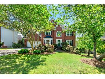 Charming two-story brick home featuring a well-manicured lawn and mature landscaping at 4415 Dorset Ln, Suwanee, GA 30024