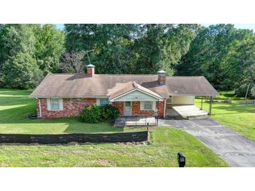 Charming brick home with mature trees and a spacious front yard at 5690 Abbotts Bridge Rd, Johns Creek, GA 30097