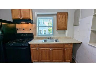 Compact kitchen features an updated sink, cabinetry and modern gas range and refrigerator at 103 Rigby Ne St, Marietta, GA 30060
