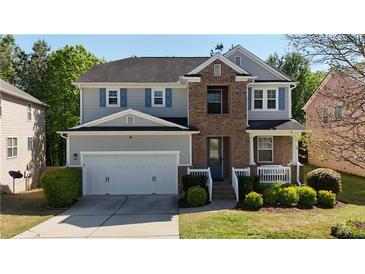 Charming two-story home boasts a well-manicured lawn and a two-car garage at 985 Forest Knoll Court Ct, Lithia Springs, GA 30122
