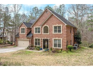 Beautiful two-story brick home featuring a well-manicured lawn and an attached two-car garage at 1705 Butler Bridge Rd, Covington, GA 30016