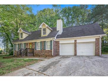 Charming brick home features a two-car garage, dormer windows, and a welcoming front entrance at 495 Buttercup Trl, Lawrenceville, GA 30046