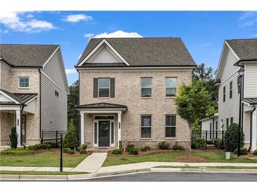 Charming two-story brick home with a covered front porch and professionally landscaped front yard at 1179 Bennett Creek Overlook, Suwanee, GA 30024
