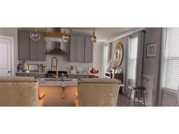 Bright kitchen features gray cabinets, gold fixtures, stainless steel appliances, and a stylish center island at 1179 Bennett Creek Overlook, Suwanee, GA 30024