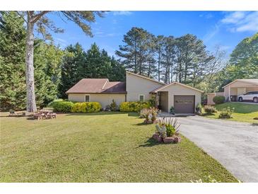 Charming home with well-manicured lawn, lush landscaping, and attached garage at 2520 Hartford Dr, Ellenwood, GA 30294