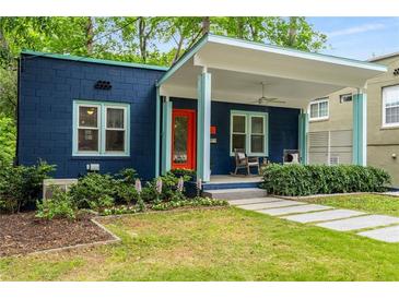 Charming blue bungalow with vibrant orange door and inviting covered front porch with rocking chairs at 830 Belgrade Ne Ave, Atlanta, GA 30306