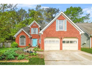 Charming two-story brick home with a manicured front yard, two-car garage, and inviting turquoise front door at 782 Ridgeland Trl, Clarkston, GA 30021