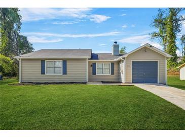 Charming single-story home with a well-manicured lawn, attached garage, and cozy curb appeal at 1158 Crystal Lake Rd, Atlanta, GA 30349