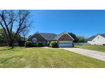 Charming brick home featuring an attached garage, manicured lawn, and well-maintained landscaping at 116 Ridge Xing, Temple, GA 30179