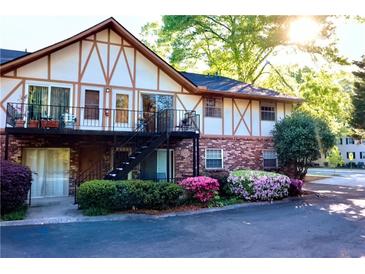 Charming townhome with brick facade, upstairs balconies, and colorful flowering bushes at 1181 Church St # D, Decatur, GA 30030