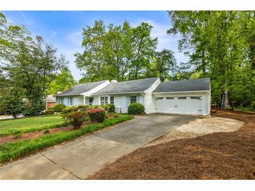Charming one-story home with a well-maintained lawn, mature trees, and a two-car garage at 568 Timberland Dr, Atlanta, GA 30342