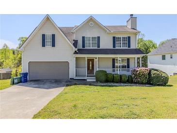 Charming two-story home with a well-manicured front yard, covered porch, and attached garage at 4357 James Wade Dr, Snellville, GA 30039