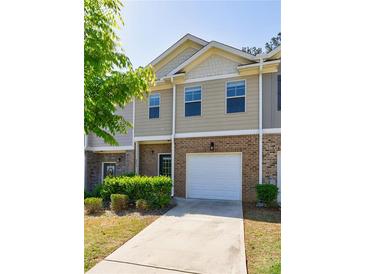 Charming townhome with brick and siding, featuring an attached one-car garage and well-maintained landscaping at 8475 Douglass Trl, Jonesboro, GA 30236