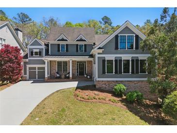 Charming two-story home with gray siding, brick accents, manicured lawn, and attached two-car garage at 68 Highcrest Dr, Acworth, GA 30101