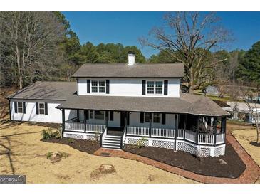 Charming two-story home boasts a covered front porch, white siding, and black shutters, creating a welcoming curb appeal at 813 Sandy Creek Rd, Fayetteville, GA 30214