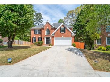 Charming two-story brick home with a well-manicured lawn and a long driveway at 3819 Meandering Sw Way, Lilburn, GA 30047