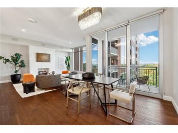 Bright living room with fireplace, hardwood floors, modern furnishings, and balcony access at 1820 Peachtree Nw St # 804, Atlanta, GA 30309