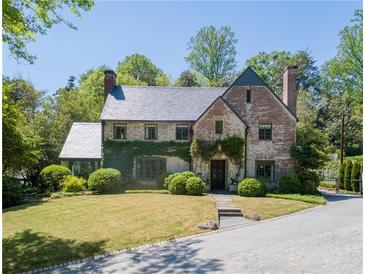 Charming brick two-story home with a well-manicured lawn and lush landscaping at 2648 Rivers Nw Rd, Atlanta, GA 30305