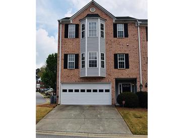 Charming brick townhome with attached garage and classic black shutters offers curb appeal at 1703 Feast Ct, Cumming, GA 30040