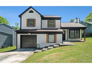 Charming two-story home with a manicured lawn, black trim, wood shutters, and attached garage in a suburban neighborhood at 1703 Laurel Creek Cir, Lithonia, GA 30058