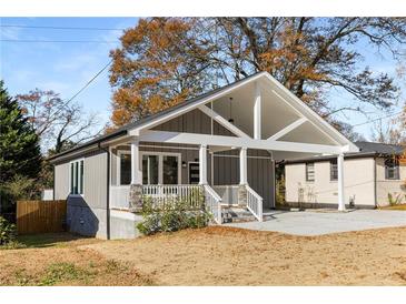 Charming home with a gray exterior, a covered porch and a spacious carport, all sitting on a well-maintained lot at 221 Silver Springs Sw Cir, Atlanta, GA 30310