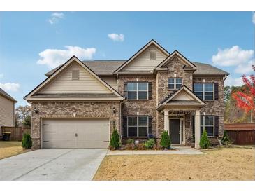 Charming two-story brick home with a well-manicured lawn and attached two-car garage at 1645 Dahlia Dr, Cumming, GA 30040