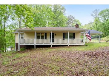 Charming single-story home with a welcoming front porch and well-maintained lawn surrounded by lush greenery at 1943 Scott Rd, Canton, GA 30115