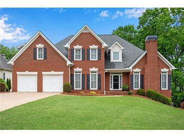 Charming brick home with a well-manicured lawn and a two-car garage at 3110 Royal Troon, Woodstock, GA 30189