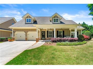 Charming single-Gathering home featuring a manicured lawn, inviting front porch, and two-car garage at 625 Aunt Lucy Sw Ln # 61, Smyrna, GA 30082