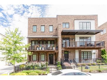 Beautiful brick townhome featuring a covered balcony and professionally landscaped front yard at 1952 Maritime Way, Atlanta, GA 30318