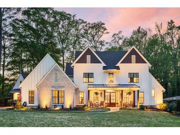 Charming exterior featuring a well-manicured lawn, white siding, brick accents and a cozy front porch with rocking chairs at 284 Hook St, Alpharetta, GA 30009