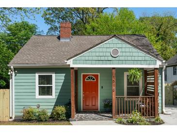Charming bungalow-style home featuring a red door, green siding, and a well-manicured front yard at 1518 Langston Sw Ave, Atlanta, GA 30310
