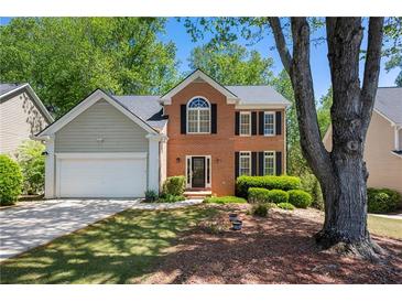 Charming two-story brick home featuring black shutters, lush landscaping, and a well-manicured lawn at 160 Brookhollow Trce, Alpharetta, GA 30022