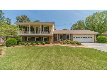 Charming brick home with a well-manicured lawn and an inviting second story balcony at 1924 Windburn Ct, Snellville, GA 30078