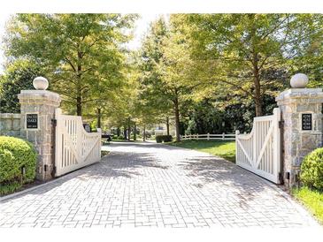View of the Paces Oaks neighborhood entrance showing brick driveway through a double gate at 4266 Paces Ferry Road Se, Atlanta, GA 30339