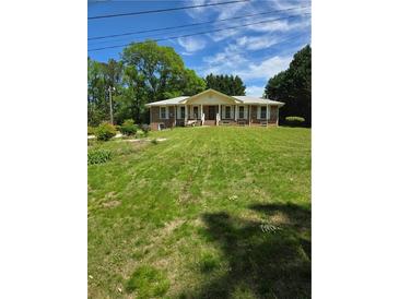 Charming brick home with a well-manicured lawn and inviting front porch at 2126 Monterey Dr, Snellville, GA 30039