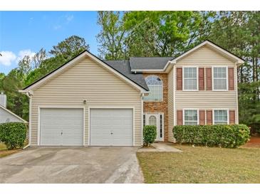 Charming two-story home with a two-car garage, neutral siding, and complementary stone accents, surrounded by mature trees at 2640 Thunder Basin Way, Douglasville, GA 30135