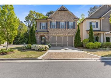 Charming brick home with a well-manicured lawn and two-car garage and stone driveway at 3715 Lexington Rd, Tucker, GA 30084