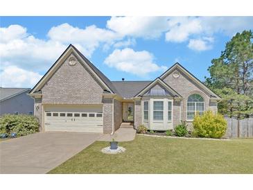 Charming single-Gathering home features a well-maintained lawn, attached two-car garage, and classic brick facade at 2800 Araglin Dr, Dacula, GA 30019
