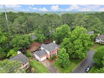 Stunning aerial view of brick home nestled in a lush, green neighborhood at 4213 Schooner Ne Ct, Roswell, GA 30075